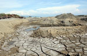 A dried-up pond is seen next to vehicles and equipment at an abandoned magnetite or black sand mine site along the coast of Caoayan town, Ilocos sur province. AFP PHOTO