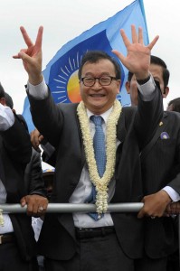 Opposition leader Sam Rainsy of the Cambodia National Rescue Party greets his supporters along a street in Phnom Penh on Friday.  AFP PHOTO