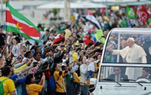 Pope Francis waves at the faithful standing on the beachfront as he arrives at Copacabana beach to participate in a re-enactment of the 14 Stations of the Cross in Rio de Janeiro. AFP PHOTO