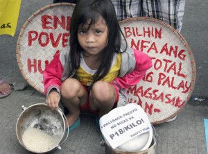 A girl takes part in a rally mounted by Bantay Bigas in front of the Department of Agriculture office in Quezon City on Wednesday to denounce the high price of rice. Photo by Mike de Juan 