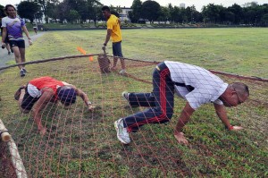 Sports enthusiasts crawl through a net obstacle in the 1st Philippine Marine Corps Karera Lakas Pilipinas Saturday at the Philippine Marine base in Fort Bonifacio, Taguig City. The participants wanted to experience the tough training Marines go through. Photo by Edwin Muli