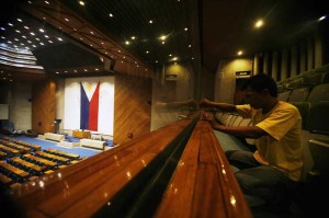 A worker cleans the newly installed glass panels lining the third floor of the Plenary Hall  of the House of Representatives in Quezon City on Friday. President Benigno Aquino 3rd  will be delivering his State of the Nation Address on Monday.  Photo By Miguel De Guzman