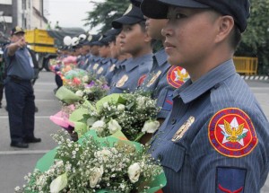 Policewomen are armed with flowers instead of truncheons as they prepare to face demonstrators near the Batasang Pambansa on SONA day Monday. Photo by Mike de Juan