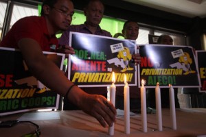  Members of the Freedom from Debt Coalition (FDC) light candles to dramatize their opposition to the proposed privatization of the Albay Electric Cooperative (Aleco) during a press conference in Quezon City on Friday. PHOTO BY MIGUEL DE GUZMAN