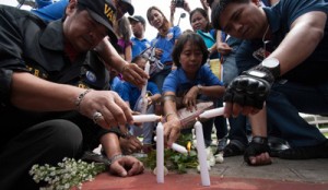 Volunteers Against Crime and Corruption members light candles to commemorate the third anniversary of the Luneta Grandstand Hostage Taking where eight Chinese tourists were killed in a botched hostage rescue. The survivors and family of the victims have sued the Philippine government. Photo By Alexis Corpuz 