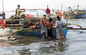 Fishermen arrive at a fishing village in Cavite on August 9, 2013. A huge oil spill shut down parts of the Philippine capital’s vital fishing industry, jeopardizing the livelihoods of tens of thousands of people living along Manila Bay’s diesel-coated coast. AFP PHOTO