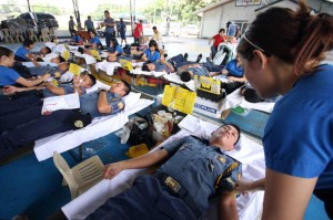 Quezon City policemen on Tuesday join a blood- letting event in Camp Karingal to support the Philippine Blood Center and expand the country’s blood banks.  Photo By Miguel De Guzman 