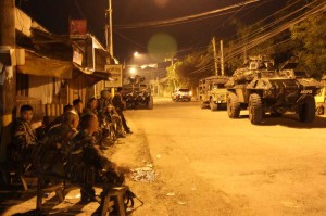 Philippine Army troops backed by armored vehicles block a road leading to the village of Mampang in Zamboanga City on Wednesday night. The soldiers were prepared to engage Moro National Liberation Front rebels, but reports say dozens of MNLF fighters had slipped through the cordon before sundown.   Photo By Al Jacinto 