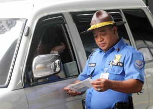 Meropolitan Manila Development Authority (MMDA) traffic enforcer Emilio Guinto reads out in English the violation of a motorist. MMDA traffic enforcers recently went through training in personality development, including good grooming and communication skills. PHOTO BY MIKE DE JUAN