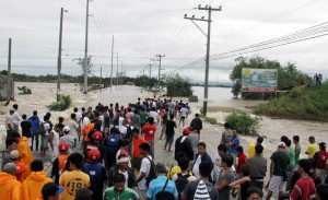 Stranded passengers wait for trucks that will ferry them from a flooded road in San Ildefonso, Bulacan.    PHOTO BY MIKE DE GUZMAN