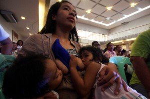 A mother breastfeeds her twins as she and more than 500 women join a massive breastfeeding program in Marikina City in a bid to make a record for having the most number of women simultaneously feeding their babies.  Photo By Miguel De Guzman 