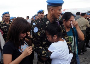 Navy Officer Marlon Fernandez comforts his family during the send-off ceremony for 12 officers and 145 enlisted personnel who will serve as peacekeepers along with the other United Nations contingents in Haiti. Photo By Edwin Muli  