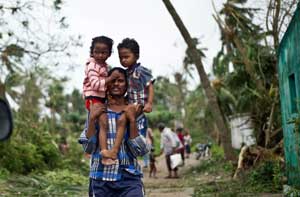 A displaced Indian man carrying his children at Sonupur village around 15 kilometers from Gopalpur on Sunday. AFP PHOTO