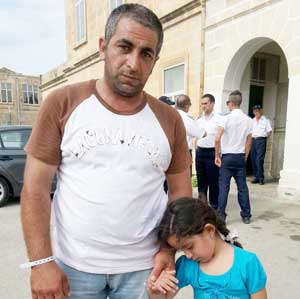 Syrian refugee Mohammed, 34, and his five-year-old daughter, pose in Valletta, on the Mediterranean island of Malta. Syrian refugees who survived after their boat capsized off Malta in the latest disaster in the Mediterranean say they were fired on by warring trafficking gangs as they set out on their perilous journey from Libya. AFP PHOTO