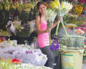 A flower vendor in Sampaloc, Manila flaunts her wares while waiting for customers. It is expected that people will come in droves for the next few days as they get ready to pay respects with flower offerings to their beloved departed during All Souls Day and All Saints Day. PHOTO BY ALEXIS CORPUZ