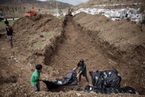 Young volunteers carry corpses of victims into a mass grave on the outskirts of Tacloban City on Thursday. Scores of decaying bodies were being taken to mass graves as authorities grappled with burying the dead.  AFP PHOTO