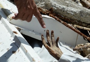  A resident points to a cadaver unearthed after tombs were swept away during the storm surge in the town of Hernani, Eastern Samar.  AFP PHOTOS 