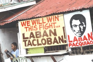 A poster rallying typhoon victims to rise from the ruins and Manny Pacquiao to vanquish his foe is seen in Tacloban, Leyte. PHOTO BY RENE DILAN