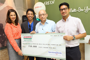 Krispy Kreme Managing Director Carlyn Trota-Salud (right) and Chairman Jim Fuentebella (left) hand over P30,000-Share the Gift of Joy check to Ricky Lepatan and Bobby Manzano of Operation Smile