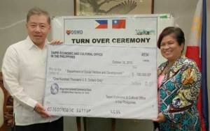 Secretary Soliman and Ambassador Wang beam as they present the check donation.