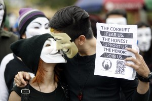 Two “hacktivists” kiss as they joined the Million Mask March in front of the House of Representatives building in Quezon City on Tuesday. The march is part of a series of mass actions calling for the scrapping of the park barrel of lawmakers. PHOTO BY MIGUEL DE GUZMAN