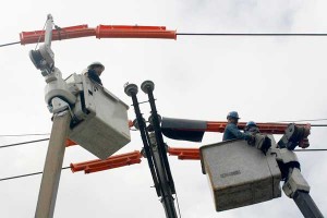 Meralco workers perform a routine check up on electricity lines along a main road in Quezon City on Sunday. Meralco warns of a power rate hike of P1 to P2 per kilowatt hour in November and December due to a scheduled Malampaya power facility maintenance shutdown. PHOTO BY MIGUEL DE GUZMAN