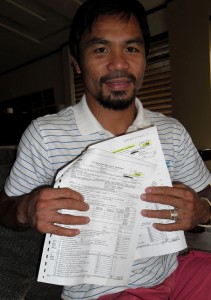 Philippine boxing hero Manny Pacquiao shows a copy of 2008 and 2009 tax returns filed with the IRS in the US, during a meeting with journalists in General Santos City, on the southern island of Mindanao on November 27, 2013. AFP PHOTO