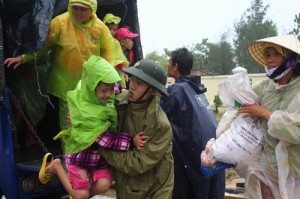 A soldier assists a young girl as villagers are evacuated to a safe place by a military truck in preparation for the arrival of the super typhoon Haiyan in the central province of Quang Nam. AFP Photo