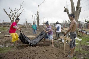 Relatives of Cristile Cahutay carry her body to a grave in Palo, Leyte on Sunday. The 22-year-old woman was washed out to sea when typhoon Yolanda hit the province. AFP PHOTO
