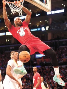 Lebron James of the Miami Heat hangs onto the rim after scoring against the Los Angeles Lakers during their Christmas Day matchup at Staples Center in Los Angeles, California.  AFP PHOTO 