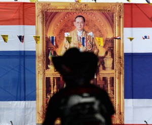 An anti-government protester standing in front of a photograph of King Bhumibol Adulyadej listens to a recorded speech in the near empty Finance Ministry in Bangkok on Friday. Thai opposition protesters were preparing to relaunch their campaign to overthrow the government after a temporary truce in the strife-hit capital for the birthday of the country’s revered king.  AFP PHOTO