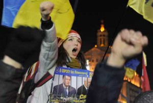 A protester holding a placard depicting Ukrainian President Viktor Yanukovych (left) and Prime Minister Mykola Azarov behind bars during an opposition rally at Independence Square in Kiev on Wednesday (Thursday in Manila). AFP PHOTO