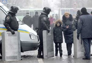 A woman and a child walk near policemen guarding the center of Kiev on Thursday (Friday in Manila). Ukraine’s opposition has called for a mass weekend rally, as pro-European demonstrators sought to increase the pressure on President Viktor Yanukovych following a failed police raid. AFP PHOTO