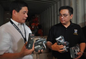 Customs chief Ruffy Biazon (right) and his deputy, Jesse Dellosa, inspect seized cell phones on Wednesday. Biazon is expected to leave his post on Friday. Photo By Edwin Muli 