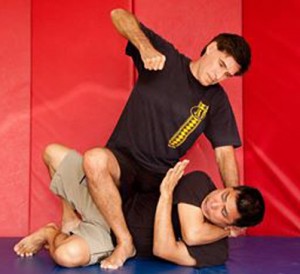 Burton Richardson demonstrates striking techniques while in the mount position during a mixed martial arts class.