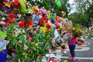 SOUTH AFRICA : Leila de Wet, two and a half years old, holds flowers in front of a wall of flowers laid by mourners outside late South African former president Nelson Mandela's home in Houghton, Johannesburg, on December 7, 2013, two days after his death. AFP Photo