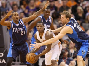 Eric Bledsoe #2 of the Phoenix Suns looks to pass guarded by Dirk Nowitzki #41 and Wayne Ellington #21 of the Dallas Mavericks during the first half of the NBA game at US Airways Center in Phoenix, Arizona. AFP PHOTO