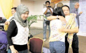 Like a sister to him, Vice Gov. Sakur Tan of Sulu embraces Mayor Maria Isabelle Salazar of Zamboanga City as a show of solidarity in government efforts to rebuild and rehabilitate Zamboanga following three weeks of street battles in September between separatist rebel and security forces. Also in the photo are Tawi-Tawi lawmaker Ruby Sahali, left, and Silsilah Foundation’s Rev. Fr. Sebastiano D’Ambra. PHOTO BY AL JACINTO