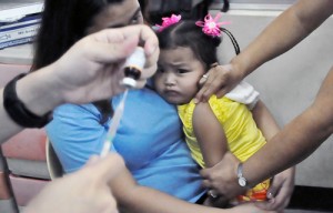 Dread is etched on this girl’s face as a nurse prepares to give her a shot against measles at the Marulas health center in Valenzuela City.  Photo By Edwin Muli 