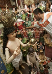 A worker arranges Santo Niño images in preparation for the feast day of the baby Jesus on Sunday. The Santo Niño festival is a big religious event in various towns and cities, including Cebu. Photo By Rene Dilan 