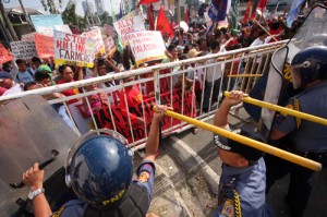 Farmers clash with anti-riot policemen during a rally near the house of President Benigno Aquino 3rd in Quezon City. The rally was held to mark the 27th anniversary of the Mendiola massacre. PHOTO BY MIGUEL DE GUZMAN 