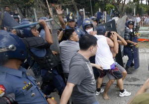 Policemen seize a man who threw rocks at them during the tension- filled demolition of squatters’ houses in Agham Road in Quezon City on Monday. The area is being cleared to pave the way for the rise of the proposed Central Business District.  Photo By Miguel De Guzman 