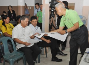 Fr. Ben Beltran, Executive Director of Sandiwaan Center for Learning, shows their learning modules to Education Secretary Armin Luistro.  PHOTO BY EDWIN MULI 