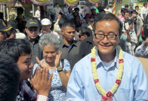 Sam Rainsy (right), leader of the opposition Cambodia National Rescue Party, greets supporters at his party’s office in Siem Reap province. AFP PHOTO