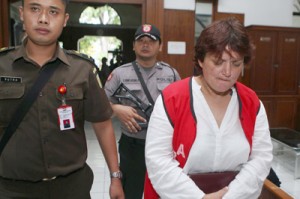 Briton Andrea Waldeck (right) is guarded by officials prior to her trial at a court in Surabaya on Wednesday. AFP PHOTO