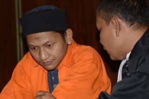 A file photo taken on November 11, 2013 shows Rokhadi (left) listening to his lawyer Willy Gustam during his trial at the South Jakarta court in Jakarta. AFP PHOTO