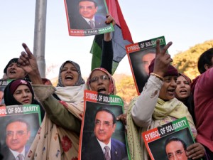 Supporters of former Pakistani President Asif Ali Zardari carry his portraits outside an anti-corruption court during his hearing in Islamabad on Thursday. AFP PHOTO