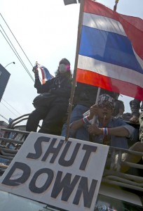 Thai anti-government protesters wave national flags as they parade during a rally in Bangkok on Friday. AFP PHOTO