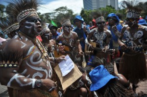 In this picture taken on January 9, 2013, Papuan mining workers sing and dance wearing their traditional costumes during a rally in Jakarta to protest the government’s new regulation, to ban the mineral export. AFP PHOTO