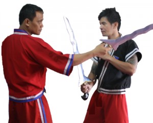 Nicolas (right) counters his opponent’s high line attack with a left hand check and a direct slash of the kris on the arm.